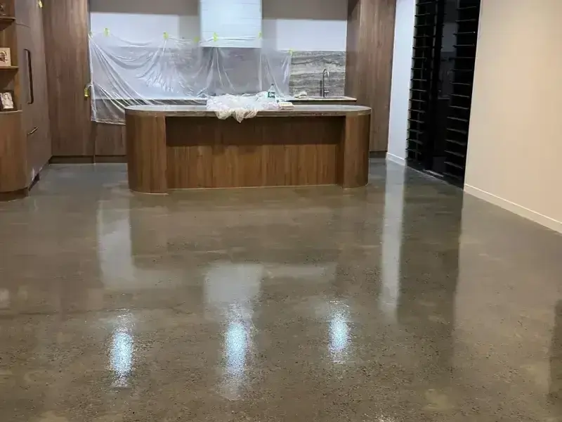 Completed high-gloss polished concrete floor reflecting ceiling lights in an Ascot kitchen